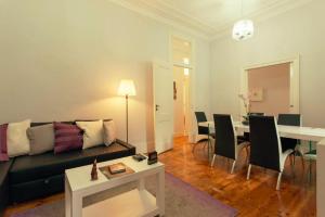 - un salon avec un canapé et une table avec des chaises dans l'établissement Traditional & Charm house in Graça, à Lisbonne