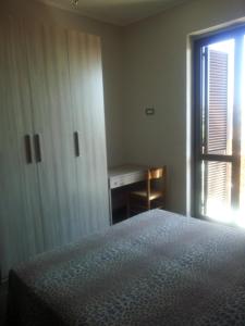 - une chambre avec un lit, un bureau et une fenêtre dans l'établissement FLORENCE srl Palace Appartamentiscilanga, à Cirò Marina