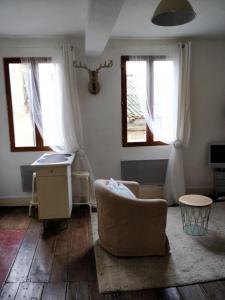sala de estar con silla y ventanas en Studio Les Armuriers, en Condom
