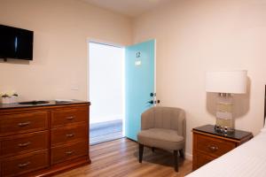 1 dormitorio con cama, silla y vestidor en Anchor Pointe Inn en Wilmington