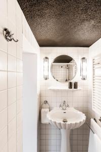 a white bathroom with a sink and a mirror at Montmartre in Zürich