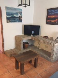 a living room with a table and a television at Casa en Bolonia muy cerca de la playa in Bolonia