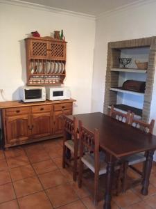 a kitchen with a wooden table and a microwave at Casa en Bolonia muy cerca de la playa in Bolonia