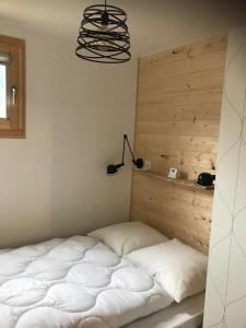 Bett in einem Zimmer mit einem Kopfteil aus Holz in der Unterkunft Charmant appartement 2 pièces - 4 personnes in Châtel