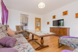 a living room with a table and a tv at Bergmann in Burgkirchen an der Alz