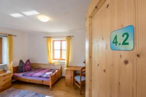 1 dormitorio con 1 cama y un cartel en la pared en Bergmann, en Burgkirchen an der Alz