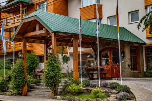 a building with a green roof and a porch at Hotel Kosten Aike in El Calafate