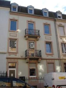 duży biały budynek z balkonami przy ulicy w obiekcie F3 lumineux & cosy au centre de Mulhouse w Miluzie