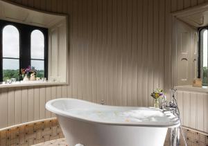 a white bath tub sitting in a bathroom next to a window at Kilkea Castle in Kilkea