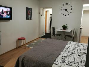a bedroom with a bed and a clock on the wall at StarHomes Hallituskatu 23 in Oulu