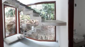 a bathroom with a stone staircase next to a window at Casa moderna perto do mar in Morro de São Paulo