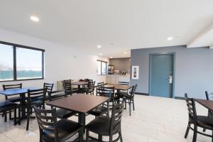 a dining room with tables and chairs and a kitchen at Americas Best Value Inn East Peoria in Peoria