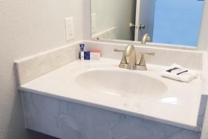a white sink sitting under a mirror in a bathroom at Americas Best Value Inn East Peoria in Peoria