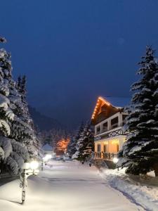 ein Haus ist nachts mit Schnee bedeckt in der Unterkunft Hotel Usengi in Elbrus