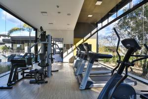 a gym with treadmills and ellipticals in a building at Quality Hotel Blumenau in Blumenau