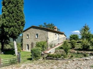 uma antiga casa de pedra com uma cerca e árvores em Villa Galearpe with private pool in Tuscany em Salutio