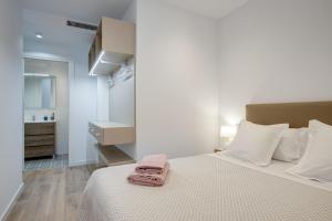 Un dormitorio con una cama con una toalla rosa. en LucasLand Apartments Barcelona, en Barcelona