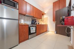 a kitchen with wooden cabinets and a stainless steel refrigerator at Athens Near Acropolis in Athens