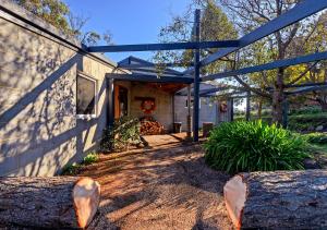 a house with a large tree stump in front of it at Taylors Bay Cottage in South Bruny
