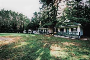 a group of houses in a field with trees at High Falls Bay Cottages, Camping & Waterpark in Bracebridge