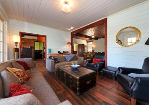 uma sala de estar com um sofá, cadeiras e uma mesa em Ventnor Guest House em South Bruny