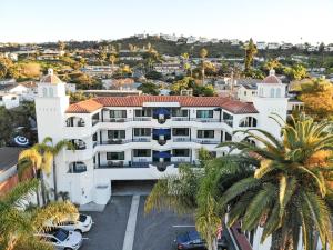 an aerial view of a white building with palm trees at The Surfbreak Hotel in San Clemente