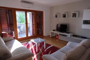 sala de estar con sofá, TV y mesa en Apartment Summertime, en Crikvenica