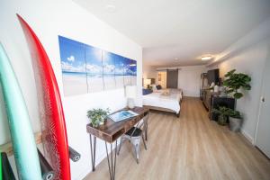 Habitación con tabla de surf y dormitorio con cama en The Surfbreak Hotel, en San Clemente