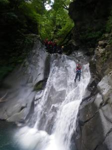 a group of people riding on a waterfall at K's House Hakuba Alps - Travelers Hostel in Hakuba