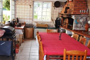 eine Küche mit einem Tisch und einem roten Tischtuch in der Unterkunft B House Verdizela in Corroios