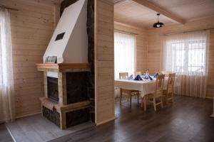 a dining room with a table and a fireplace at Котеджі “Друзі” in Bukovel