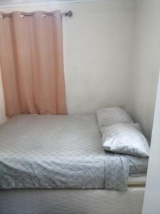 Cama en habitación con cortina y cama sidx sidx en Tonys Guest House, en Puerto España