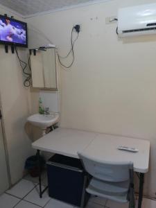 a bathroom with a white toilet and a sink at Tonys Guest House in Port-of-Spain