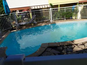 a small swimming pool with a chair in front of a fence at Ti kaz a Annick in Bouillante