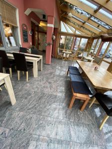 a restaurant with tables and chairs and windows at Hotel Seebach in Großenseebach