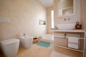 a bathroom with a white toilet and a sink at Fuoridalguscio Home in Leuca +58 photos