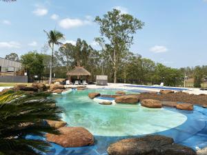 a swimming pool with blue water and rocks at The Kooralbyn Valley in Kooralbyn