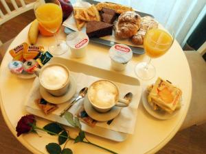 una mesa con alimentos para el desayuno y dos vasos de zumo de naranja en Dante's in Vaticano, en Roma