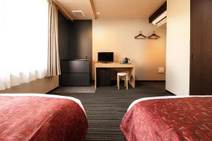 a hotel room with two beds and a desk at Connect inn Shichijo-Kamogawa in Kyoto
