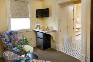 Healdsburg Inn on the Plaza, A Four Sisters Inn في هيلدسبورغ: غرفة معيشة مع كرسي ومكتب