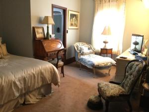 ein Schlafzimmer mit einem Bett, einem Stuhl und einem Schreibtisch in der Unterkunft Pemberley House Bed and Breakfast in Seaforth