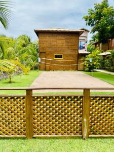 a wooden fence in front of a house at CHALES VILLAGE COR-PENINSULA DE MARAU-BAHIA in Barra Grande
