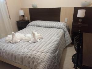 Una habitación de hotel con una cama con toallas blancas. en hotel andino en La Rioja