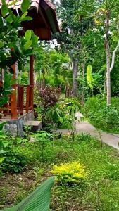 a garden with a green umbrella in the grass at Caga Garden in Nusa Penida