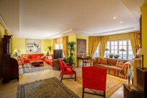 a living room with red furniture and yellow walls at Can Mandol Villa in Inca