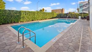 a swimming pool with a blue railing next to a building at Best Western Premier Miami International Airport Hotel & Suites Coral Gables in Miami