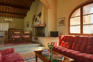a living room with two red couches and a table at Sole del Chianti in Tavarnelle in Val di Pesa