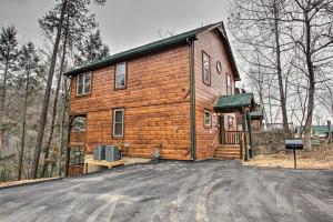 a wooden house with a driveway in front of it at Luxe Cabin with Home Theater Less Than 2 Miles to Gatlinburg in Gatlinburg
