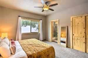 a bedroom with a bed with a ceiling fan and a window at Mountainside Fairplay Cabin with Game Room and Sauna! in Fairplay