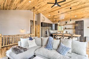 a living room with a couch and a kitchen at Mountainside Fairplay Cabin with Game Room and Sauna! in Fairplay